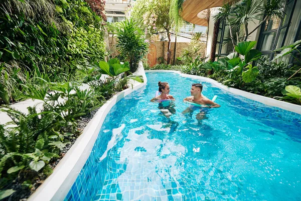 Couple Talking Swimming Foam Noodles Pool Spa Resort Beautiful Exotic — 스톡 사진
