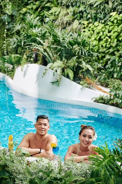 Cheerful Couple Refreshing Cocktails Leaning Edge Swimming Pool Looking Camera — 스톡 사진