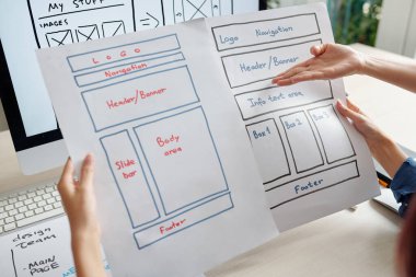 UX tasarımcı takımı toplantıda mobil cihazın iki sürümünü tartışıyor
