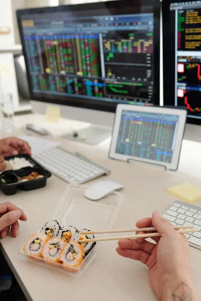 Ofis Masasında Suşi Yiyen Borsa Simsarlarının Kırpılmış Görüntüsü Bilgisayar Ekranlarında — Stok fotoğraf