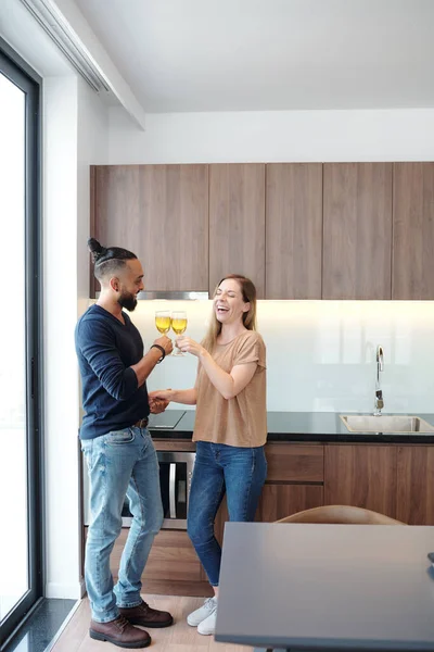 在庆祝搬进新公寓时 一对快乐的年轻夫妇举着酒杯敬酒 — 图库照片