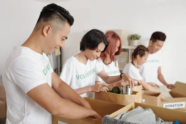 Grupo Jovens Voluntários Asiáticos Embalando Alimentos Roupas Caixas Papelão Para — Fotografia de Stock