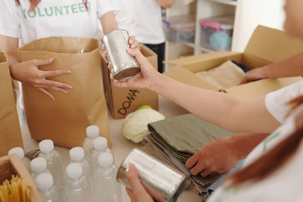Nahaufnahme Von Freiwilligen Die Konserven Wasser Und Kleidung Kartons Verpacken — Stockfoto