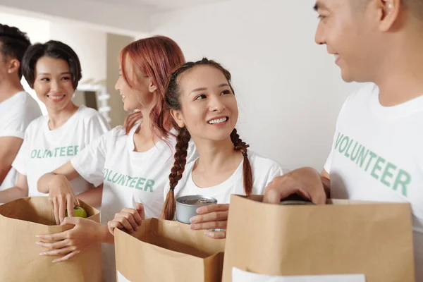 Hübsche Junge Lächelnde Frau Die Mit Ihren Freundinnen Spendenzentrum Hilft — Stockfoto