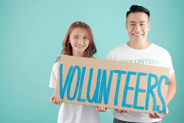Gülümseyen Genç Asyalı Erkek Kadın Ellerinde Gönüllülerin Yazılı Olduğu Büyük — Stok fotoğraf