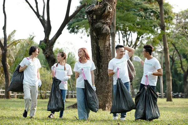 Jóvenes Voluntarios Alegres Sosteniendo Bolsas Plástico Limpiar Parque Recoger Basura —  Fotos de Stock