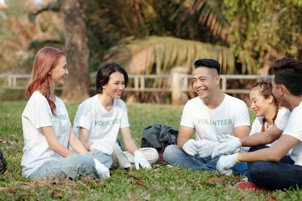 Grupo Jovens Sorridentes Sentados Grama Parque Cidade Discutindo Voluntariado — Fotografia de Stock