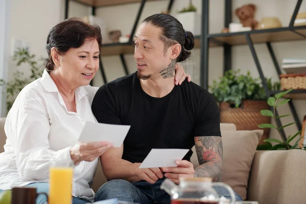 Mista Donna Matura Parlando Con Figlio Adulto Mostrandogli Vecchie Foto — Foto Stock