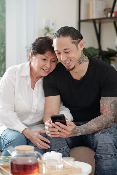 Sonriente Hombre Raza Mixta Visitando Madre Mostrando Sus Fotos Videos —  Fotos de Stock