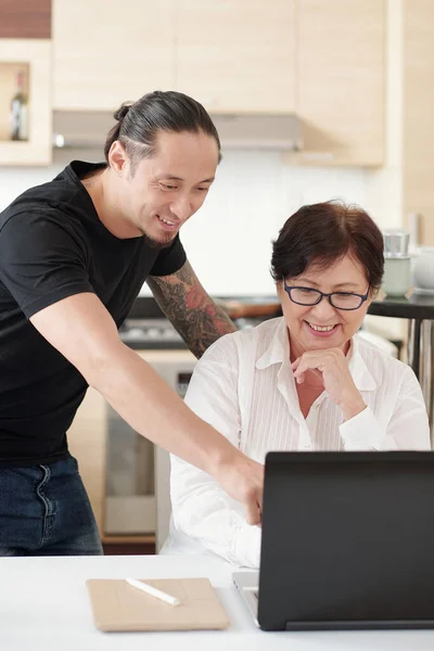Sorrindo Mestiço Homem Explicando Mãe Como Usar Novo Laptop Encontrar — Fotografia de Stock