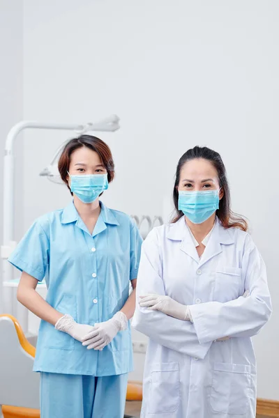 Equipo Dentista Positivo Enfermera Joven Máscaras Protectoras Pie Clínica Dental —  Fotos de Stock