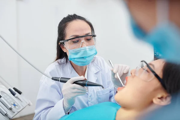 Starší Zkušený Zubař Brýlích Ochranné Masce Vrtání Zubů Pacienta Trpícího — Stock fotografie