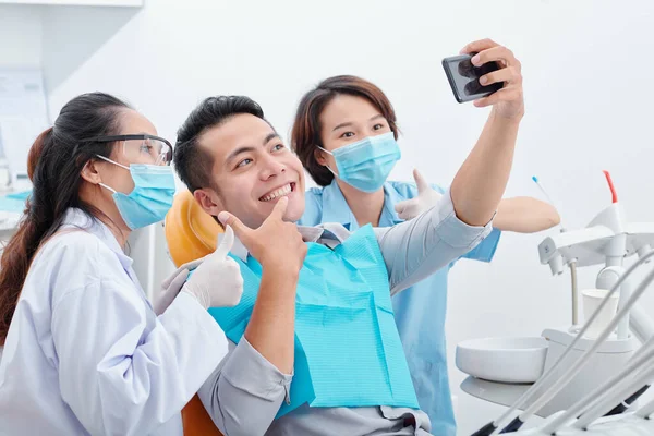 Молодой Азиат Доволен Своей Новой Улыбкой Делая Селфи Стоматологом Ассистентом — стоковое фото