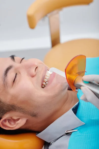 Стоматолог Использующий Стоматологический Свет Полимеризации Композитной Смолы Зубов Молодого Азиата — стоковое фото