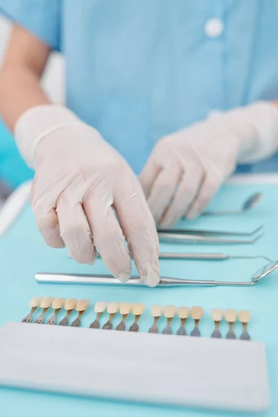 戴硅胶手套的牙医的手 将消毒工具和配色板放在托盘上 — 图库照片