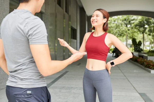 야외에서 조깅하기 전젊은 아시아 여자가 친구와 얘기하며 — 스톡 사진