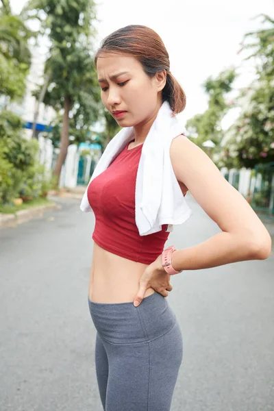 屋外で働いた後 背中の痛みに苦しむかなり若いアジアの女性 — ストック写真