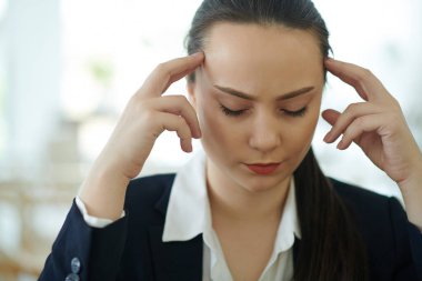 Bütün gün çalıştıktan sonra şiddetli baş ağrısı ya da migrenden muzdarip genç bir girişimci.