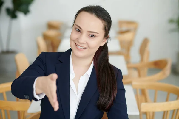 陽気な若い女性起業家挨拶ビジネスパートナーと握手のための腕を伸ばしの肖像 — ストック写真