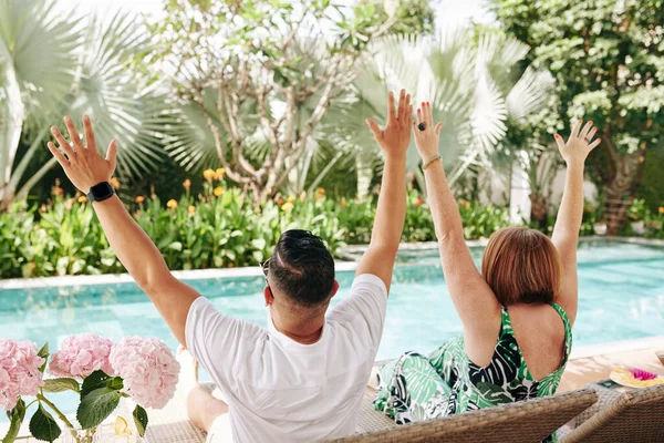 Feliz Pareja Madura Emocionada Sentada Chaise Lounges Levantando Brazos Mirando —  Fotos de Stock