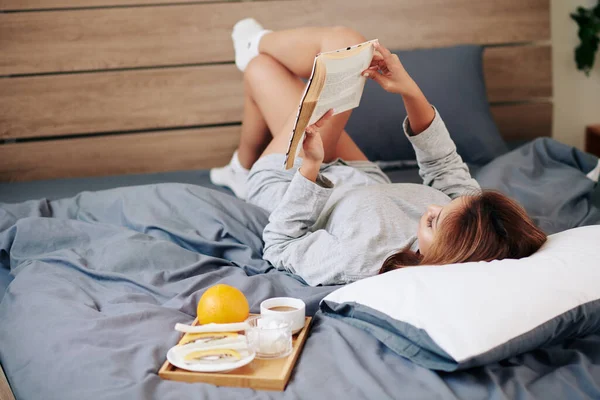 Mladá Žena Relaxuje Pohodlné Posteli Doma Čtení Podmanivé Knihy — Stock fotografie
