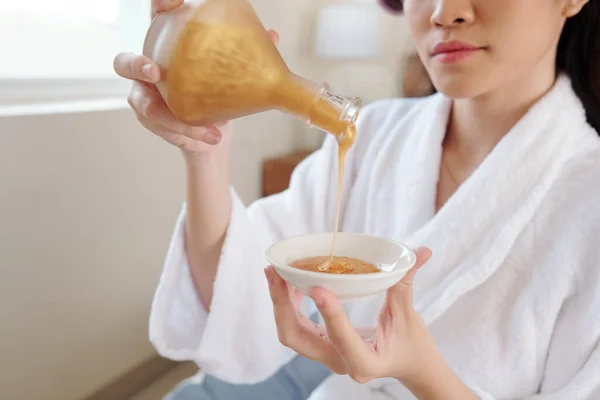 Imagem Cortada Jovem Mulher Roupão Banho Derramando Loção Hidratante Dourada — Fotografia de Stock