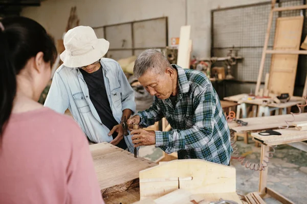 木材を扱うときに彼の孫を使用する方法を示す上級経験豊富なベトナムの大工 — ストック写真