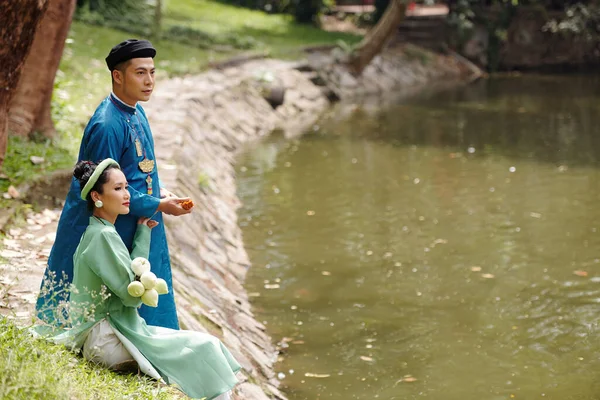 Feliz Joven Pareja Asiática Dai Vestidos Sentado Junto Río Parque — Foto de Stock