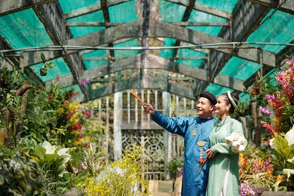 Šťastný Mladý Vietnamský Muž Ukazuje Krásné Květiny Skleníku Nevěstě — Stock fotografie