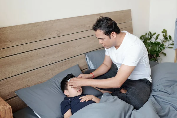 Caring Father Putting Cooling Gel Patch Forehead His Little Son — Foto Stock