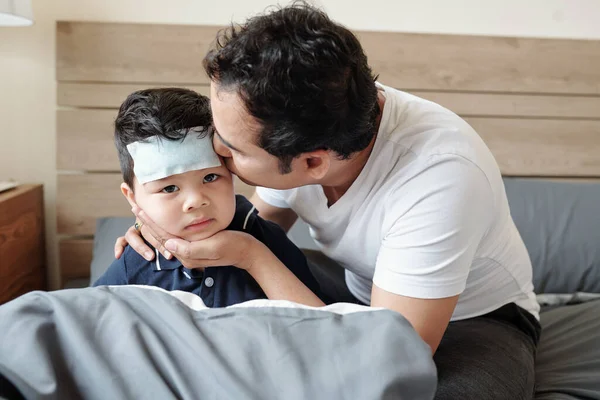 Padre Cariñoso Besando Pequeño Hijo Enfermo Con Parche Enfriamiento Frente — Foto de Stock