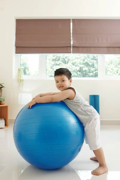 Leende Liten Pojke Står Bredvid Stora Fitness Boll Hemma Och — Stockfoto