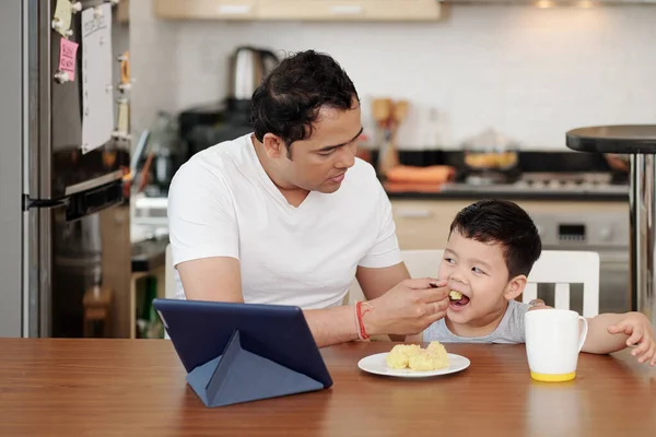 Father Feeding His Little Son Mashed Potatoes Watching Cartoon Tablet — Foto Stock