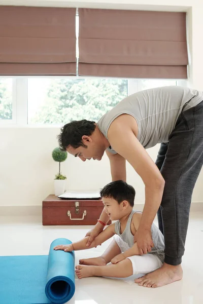 Joyful Little Boy Helping Dad Roll Out Yoga Mat Home — Foto Stock