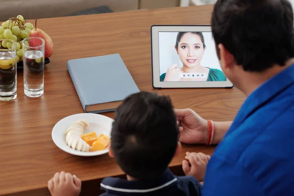 男は果物と息子を養うとき 彼らはビデオを介して母親を呼び出すテーブルコンピュータ — ストック写真