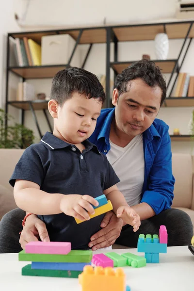 印度男人和他的儿子在家里玩彩色玩具砖 — 图库照片