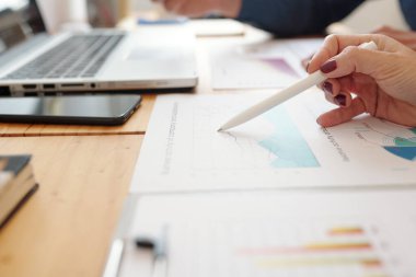 Masasında satış istatistikleri olan kadın girişimcinin yakın plan resmi.