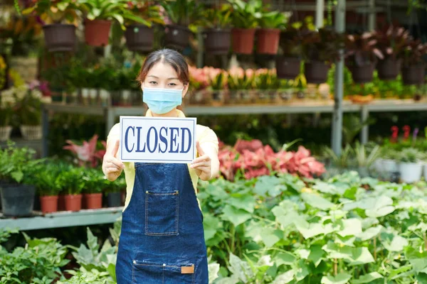 Junge Frau Mit Schutzmaske Steht Gartencenter Und Zeigt Geschlossenes Schild — Stockfoto