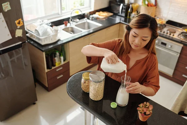 Ung Kvinna Hälla Mjölk Glasburk När Gör Frukost Vid Köksbänken — Stockfoto