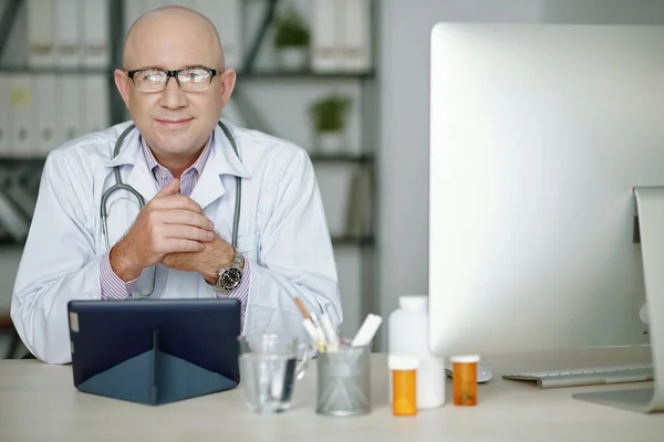 穿着白衣 头戴药丸 使用平板电脑的内容自信的成熟白人医生的画像 — 图库照片
