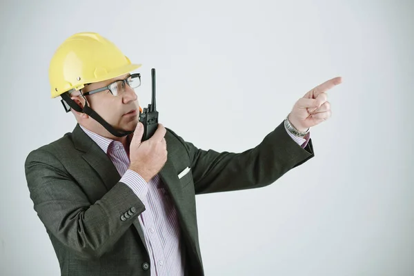 在向工人解释项目计划时 使用对讲机认真 戴工作头盔和眼镜的建筑承包商或工程师 — 图库照片