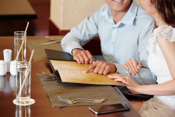 Gehakt Beeld Van Lachend Jong Koppel Wijzend Naar Restaurant Menu — Stockfoto