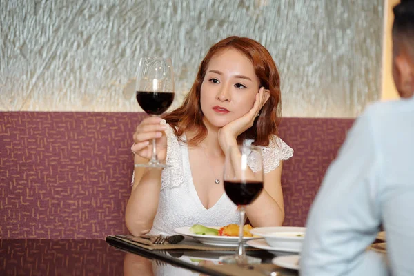 Aufmerksame Junge Frau Schaut Auf Ein Glas Wein Wenn Sie — Stockfoto