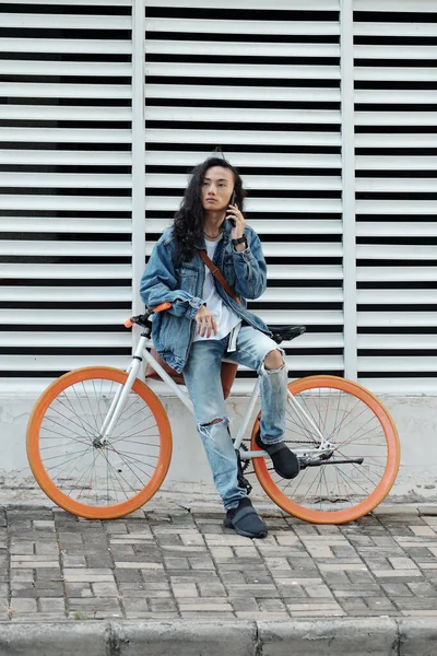 Ciddi Düşünceli Siyah Uzun Saçlı Bisikletli Genç Vietnamlı Bina Panjuru — Stok fotoğraf