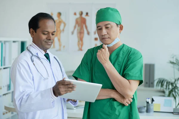 Médicos pensativos mirando rayos X — Foto de Stock