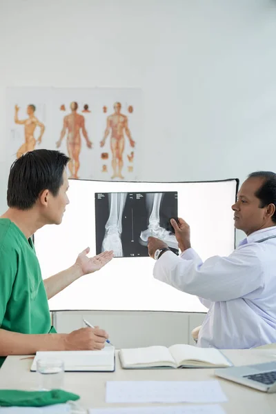 Хирург и рентгенолог обсуждают перелом пятки — стоковое фото