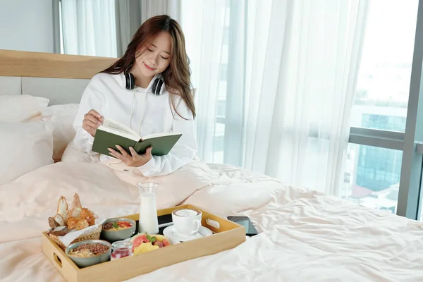 Žena čtení v posteli — Stock fotografie