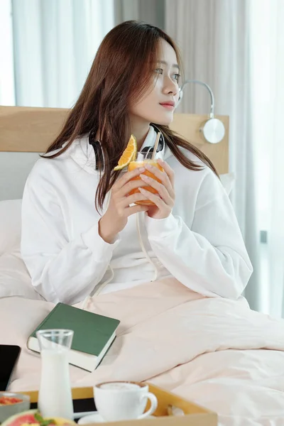 Zamyślona kobieta pijąca sok — Zdjęcie stockowe