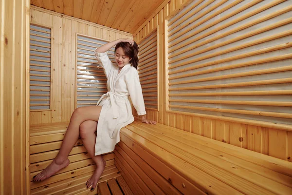 Giovane donna seduta in sauna — Foto Stock