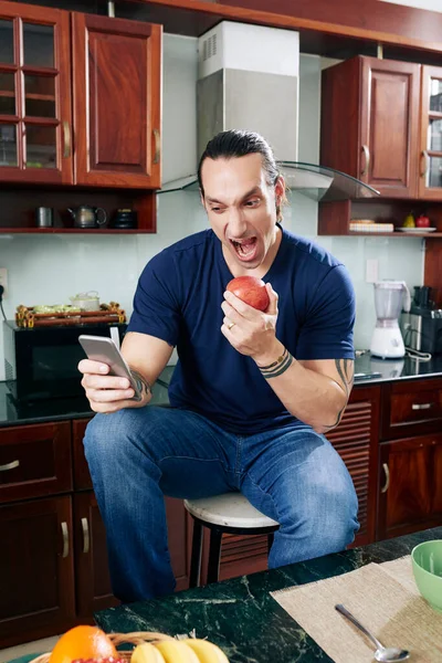 Hombre enojado comiendo manzana — Foto de Stock